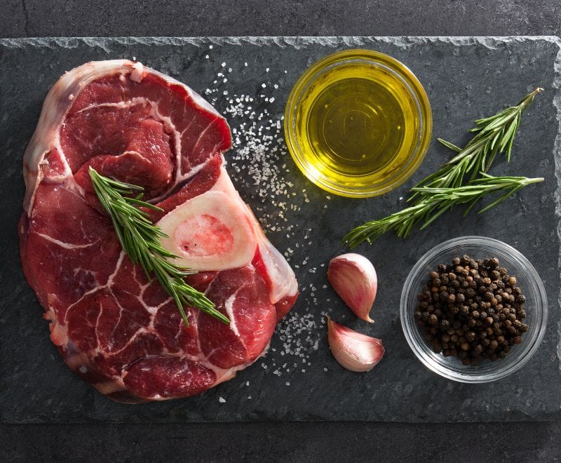 Raw beef shin steak with rosemary and garlic