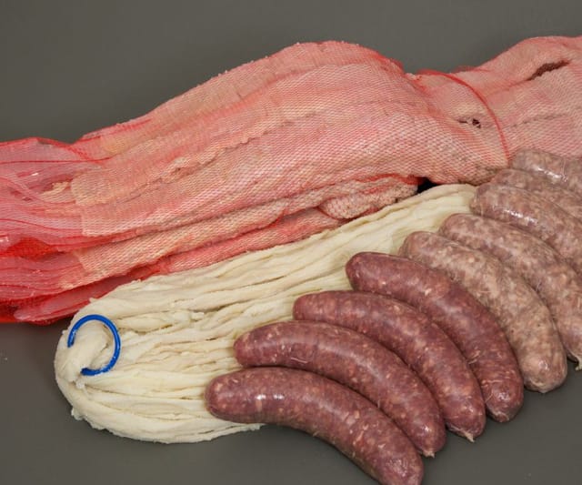 Salted hog casings in red nets with a soft tube and fresh sausages