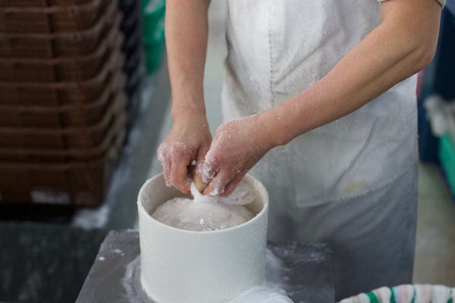 Hands sorting salted casings in a bucket