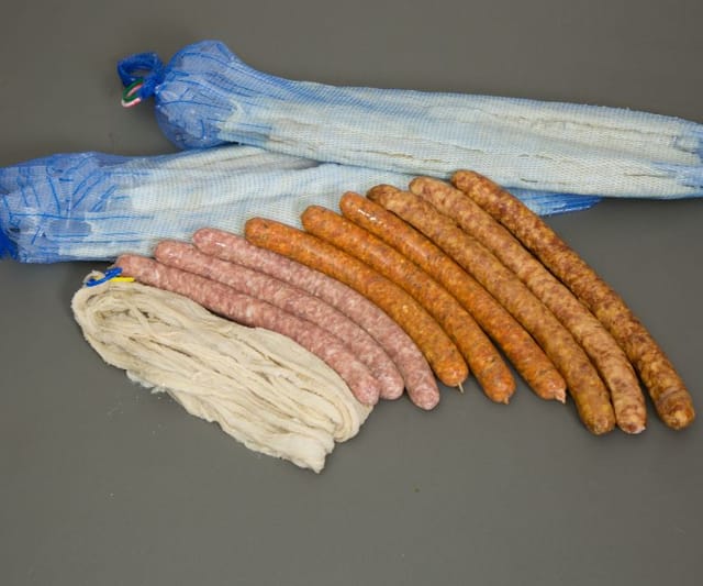Sheep casings on soft tubes next to a hank and fresh sausages